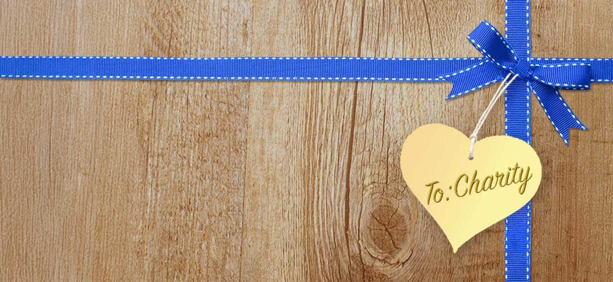 To Charity tag on blue ribbon and wood box background