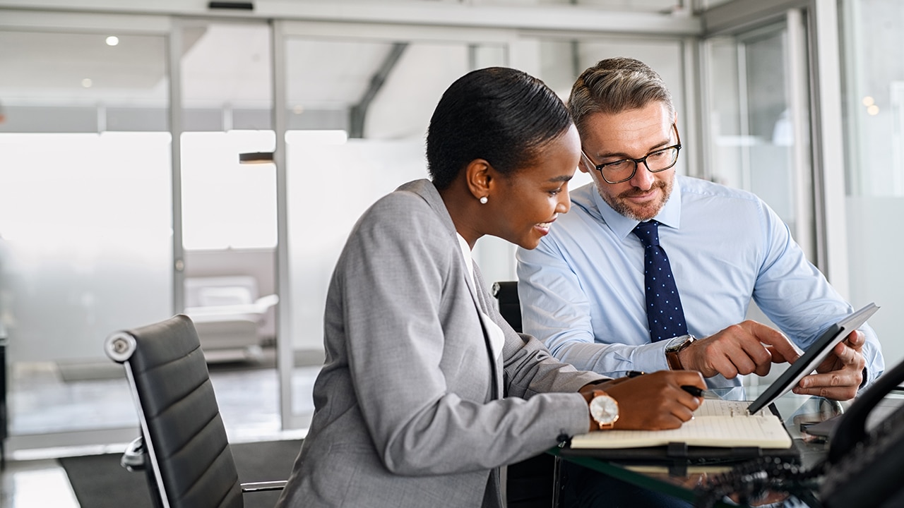 2 people talking and looking at the screen