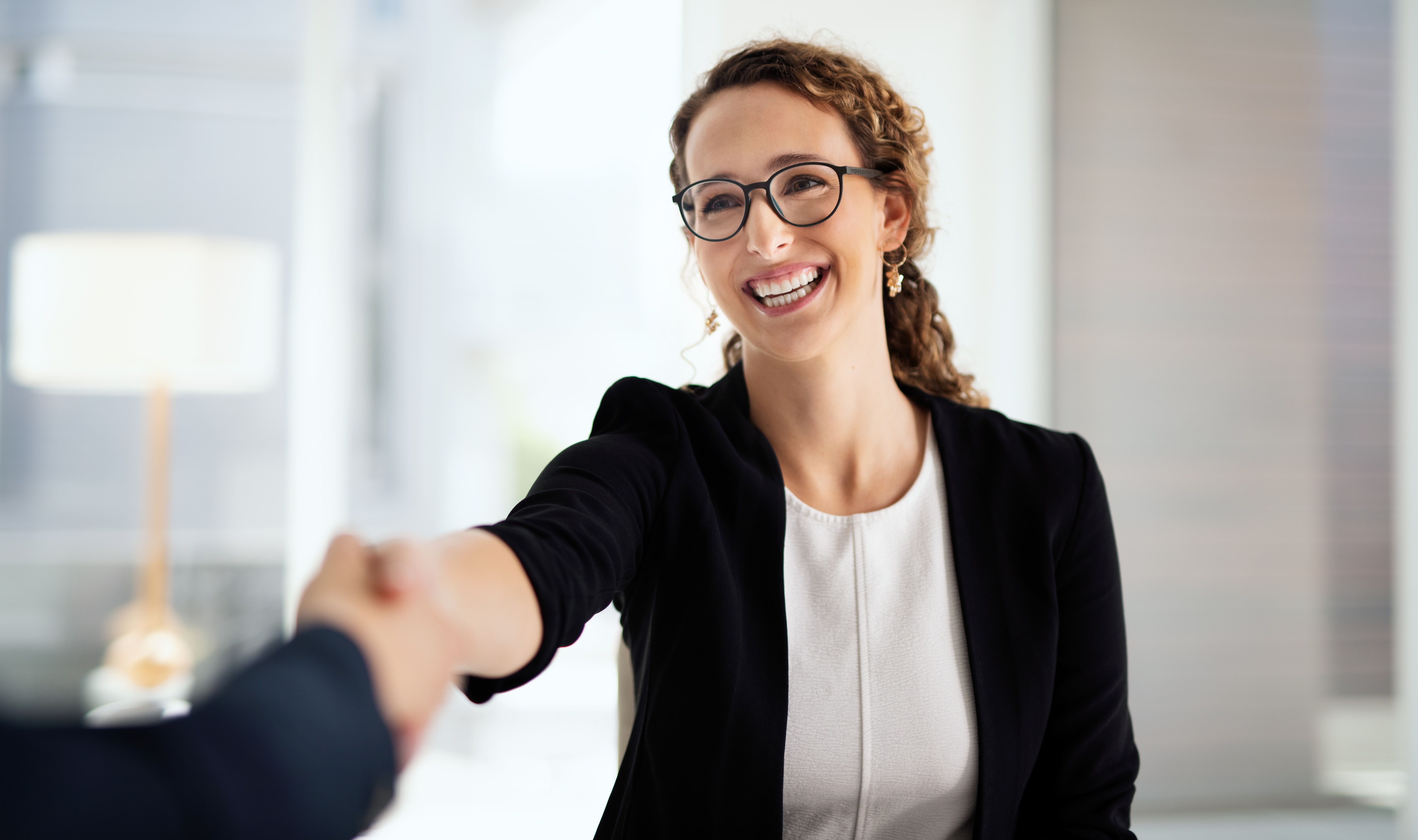 Shot of two businesswomen shaking hands in a modern office