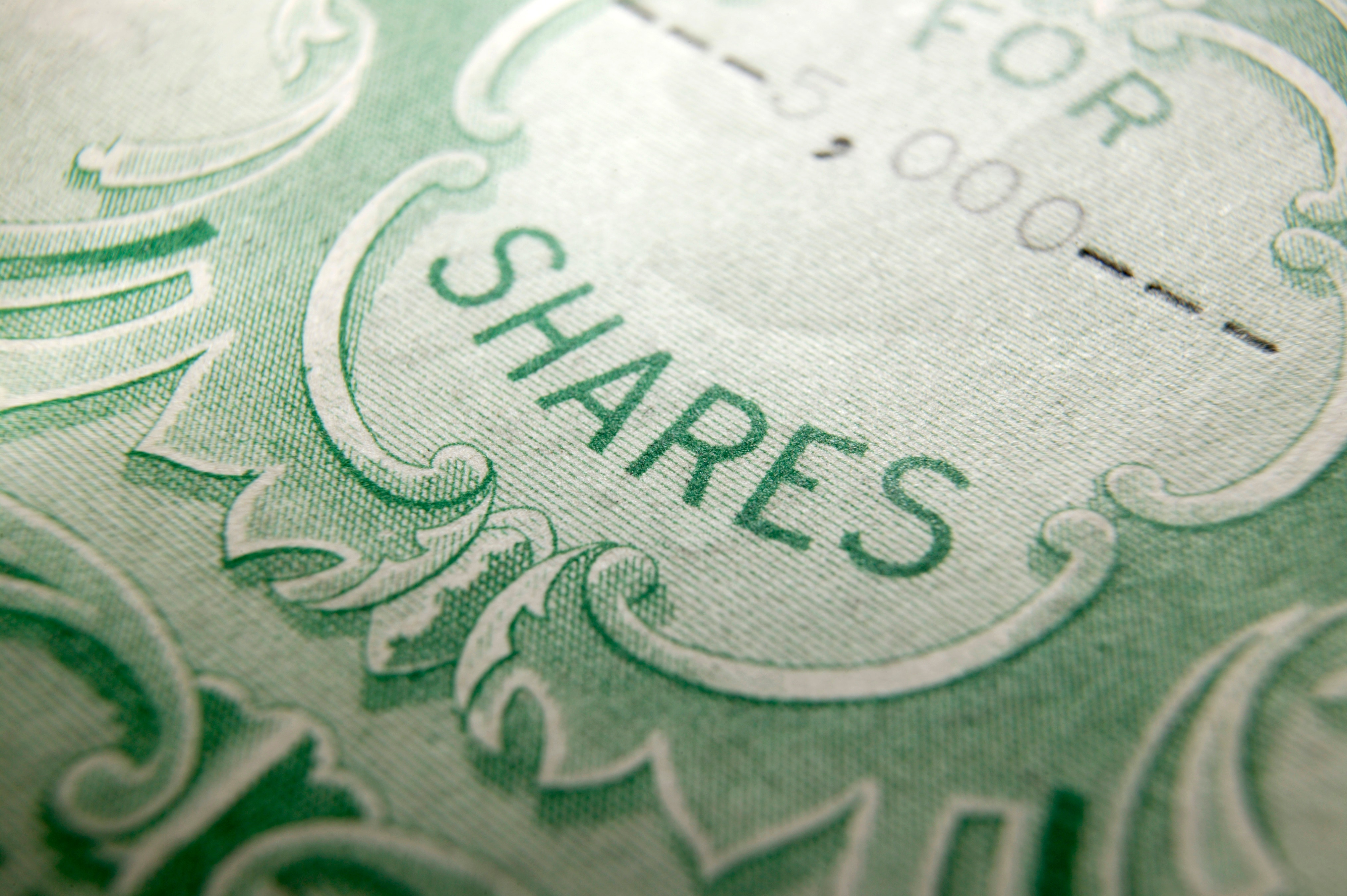Closeup of stock certificate emphasizing the word shares