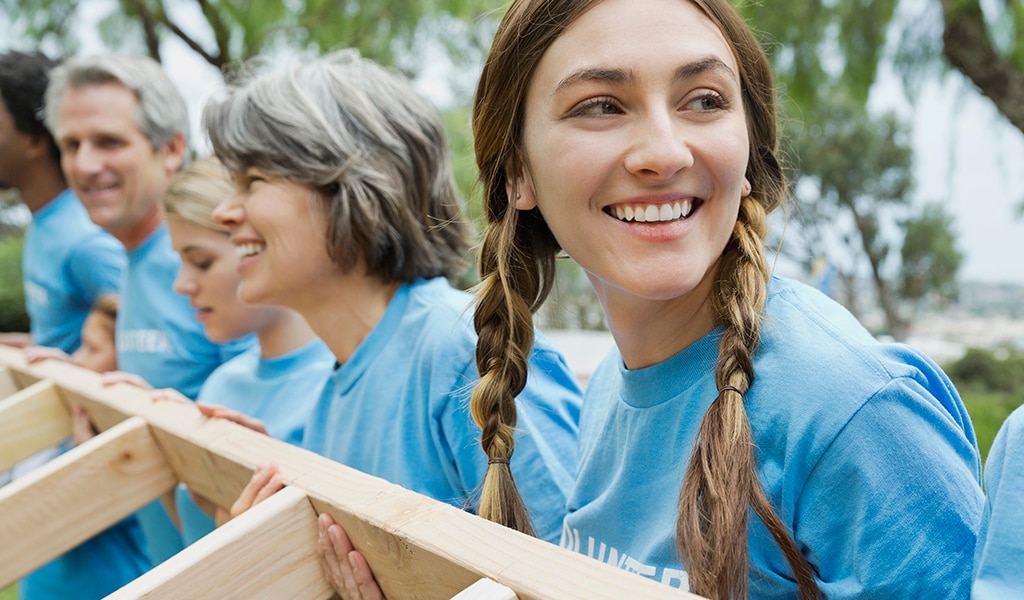 Volunteers raising wooden frame