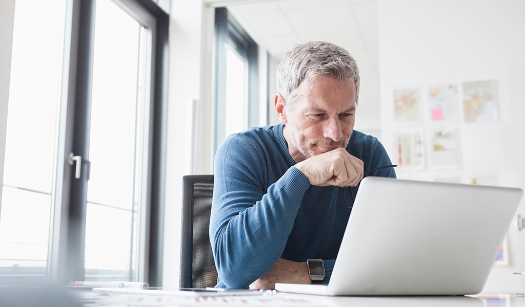 Older gentleman studying content on laptop