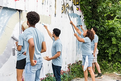 Volunteers painting the side of a barn