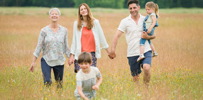 alt=Four generations of a family exploring a beautiful meadow.