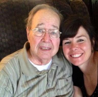 A woman smiling next to her elderly father